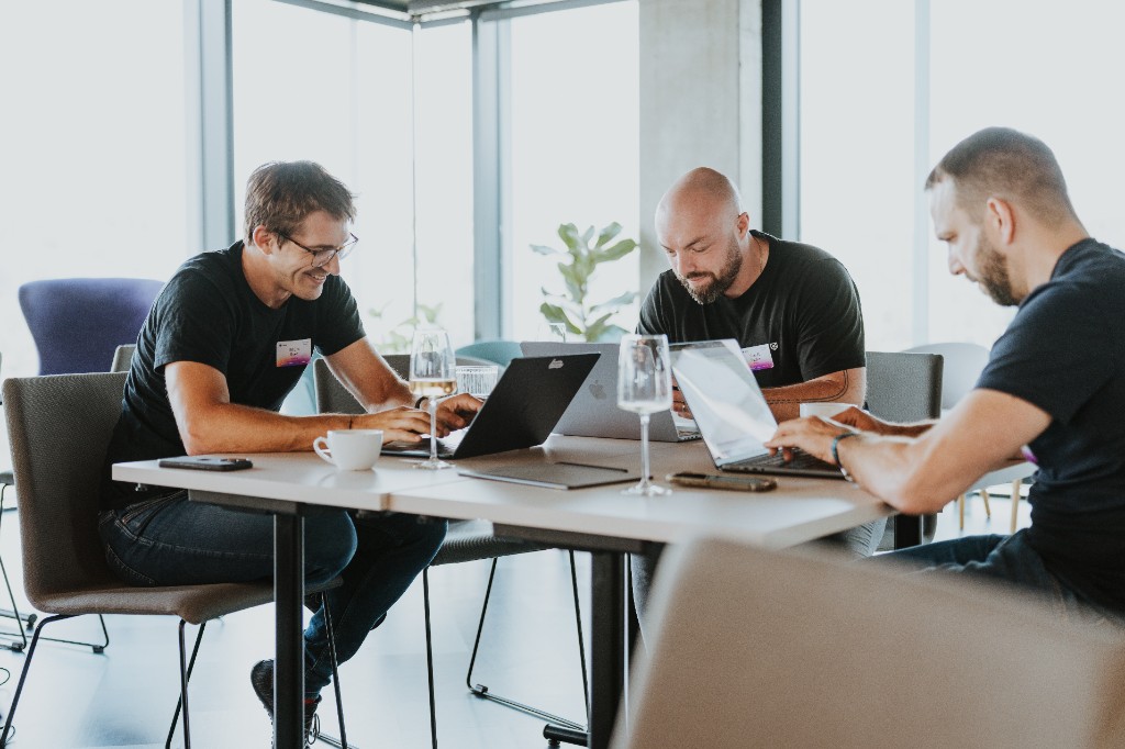Profesionálové pracují na noteboocích během AI workshopu