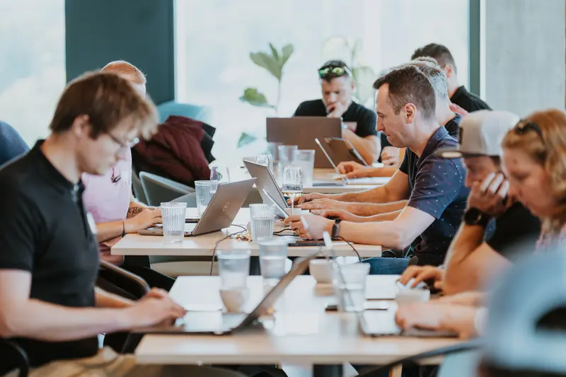 Specialisté a marketéři pracují s notebooky u dlouhého stolu